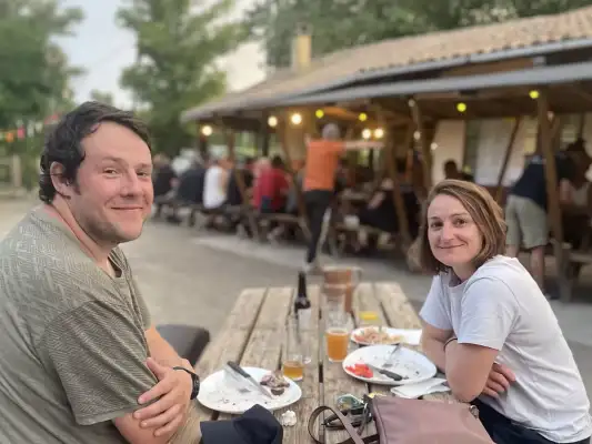 Gasten op het terras bij Le Camping Moto